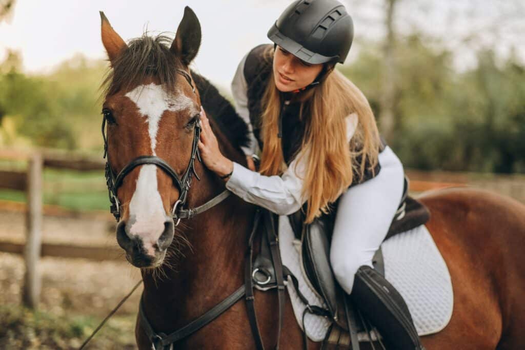 Young rider bonding with her horse before training